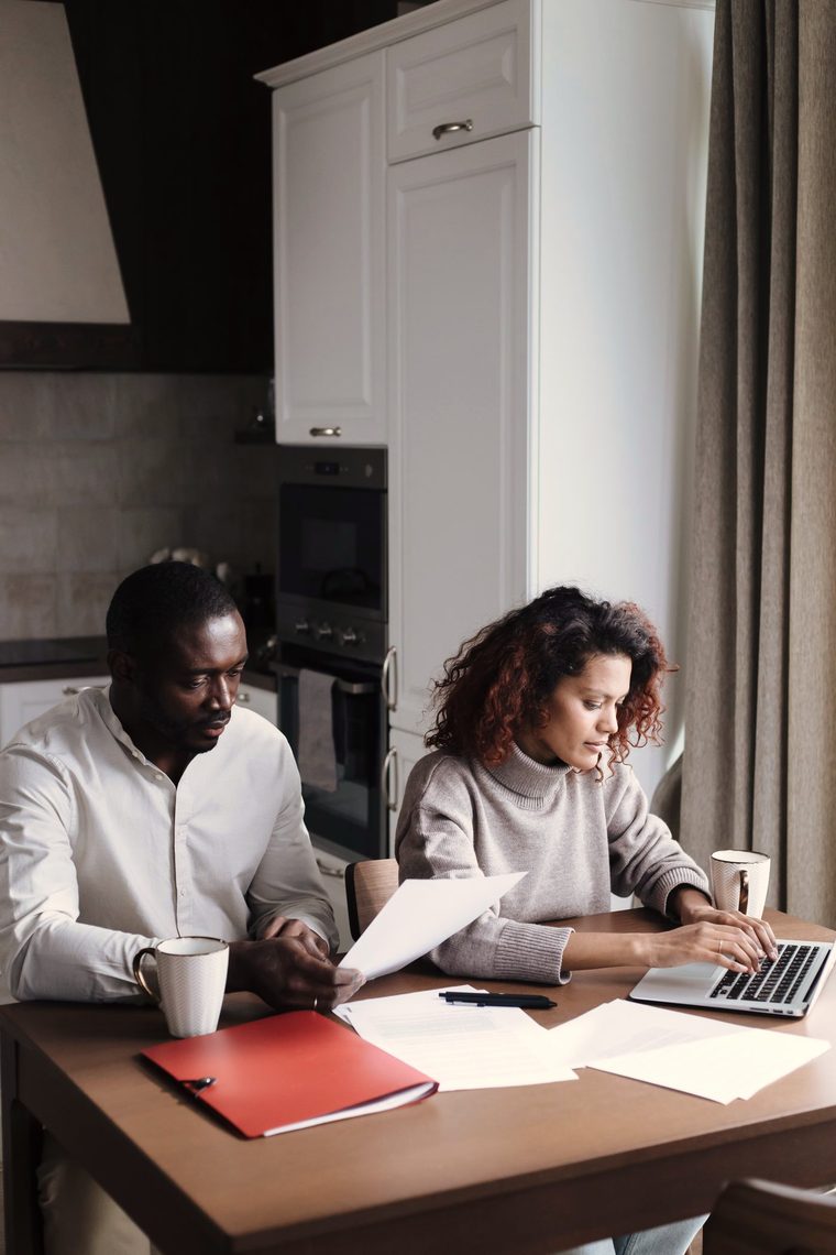 A working-age couple going over paperwork together at home